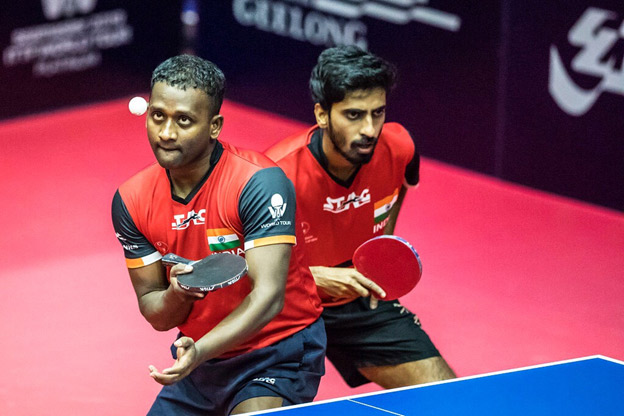 Amal Raj in serving position, Sathiyan in photo